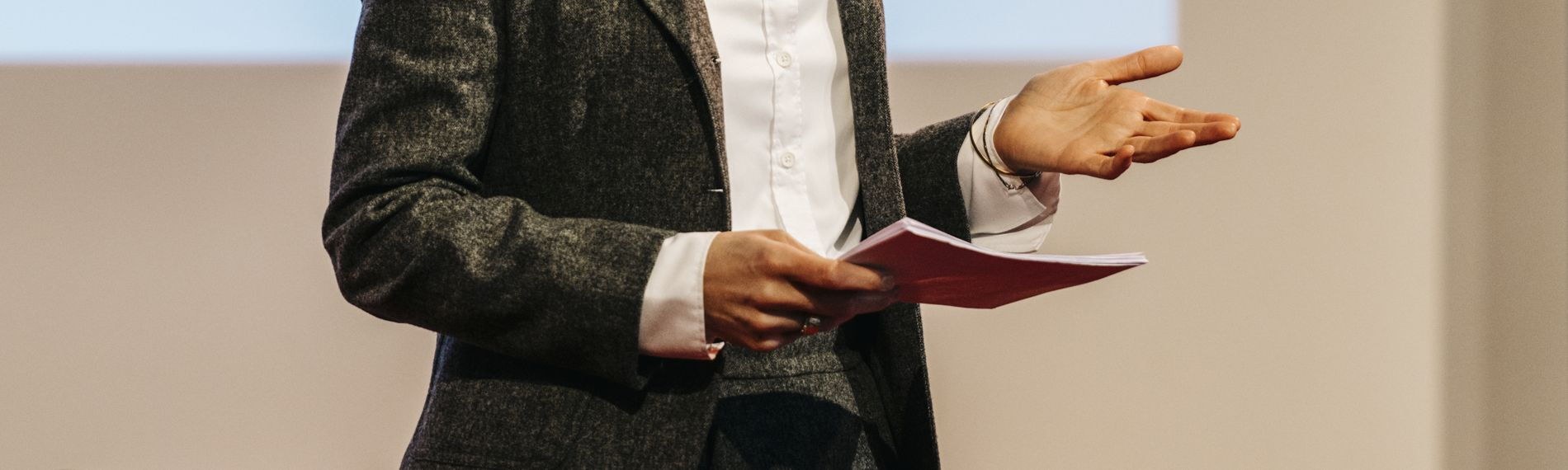 Hände einer Person, die auf einer Konferenz einen Vortrag hält